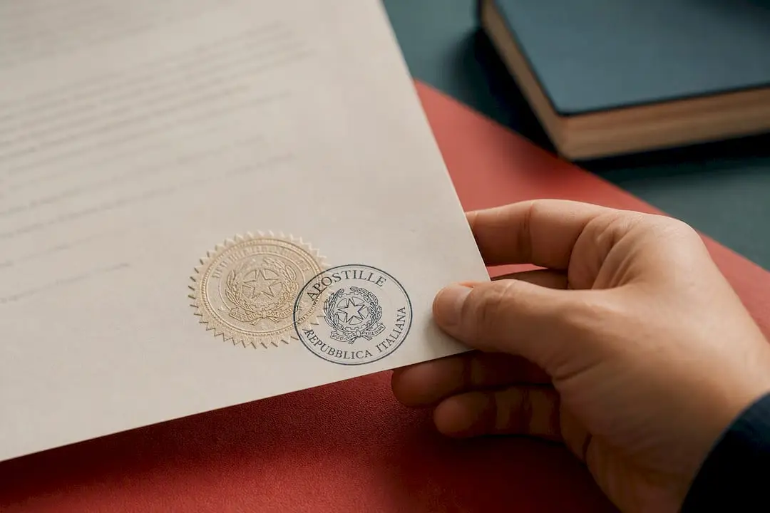 Hand holding document with Italian apostille stamp