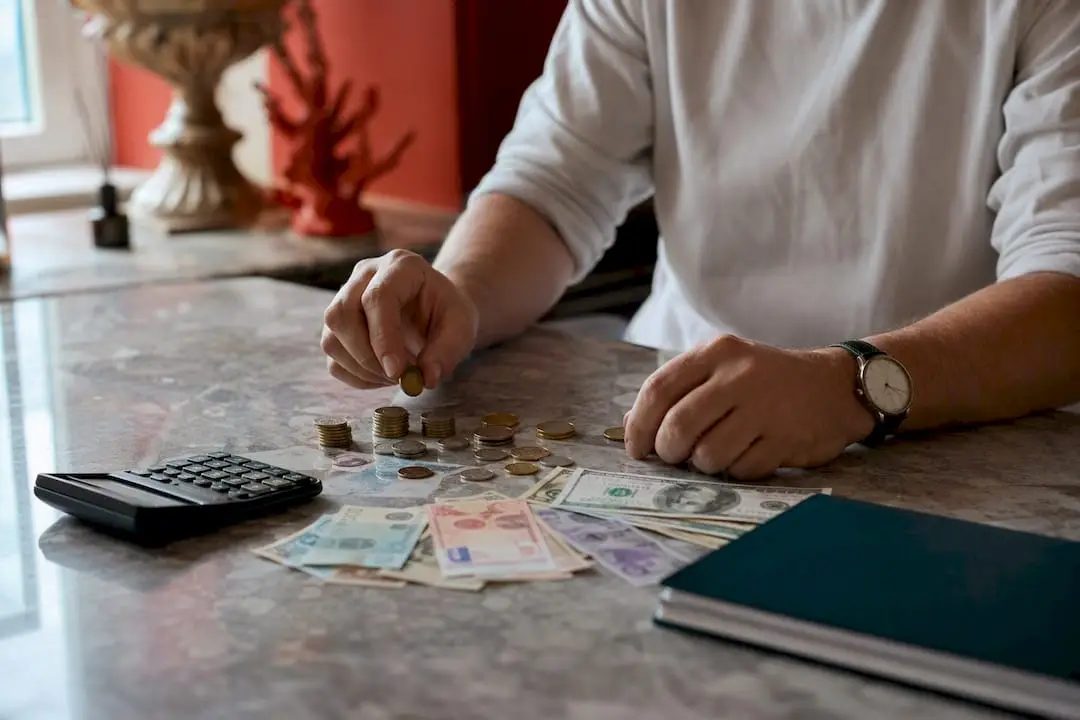 Hands comparing euro coins and foreign banknotes